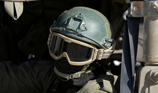 An Israeli soldier drives in a vehicle on the separation line with Gaza, as seen from southern occupied Palestine, Friday, Oct. 18, 2024. (AP Photo/Tsafrir Abayov)