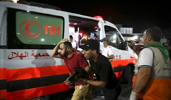 Palestinian medics help a man wounded in Israeli strikes in Gaza City on Oct. 13, 2023. (AP)