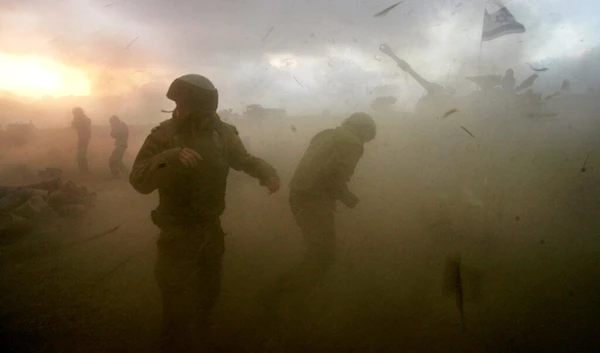 Israeli gunners react as they stand in the shock wave as an artillery piece fires into southern Lebanon from a position near Kiryat Shmona, northern occupied Palestine, in this July 14, 2006 file photo. (AP)