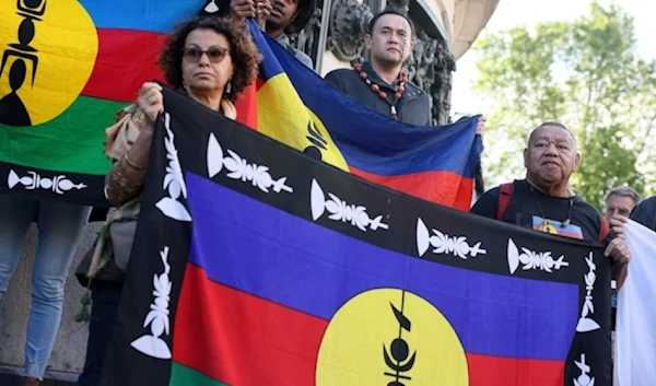 Demonstrators hold Kanak and Socialist National Liberation Front (FLNKS) flags during a gathering in Paris, on May 16,2024. (AP)