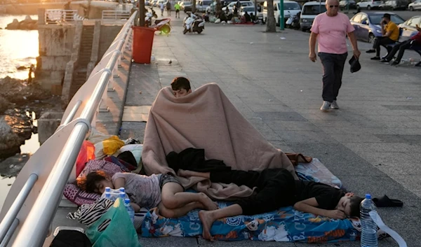 Families sleep on Beirut's corniche after fleeing the Israeli airstrikes in Beirut's southern suburb, Lebanon, Monday, Sept. 30, 2024. (AP)