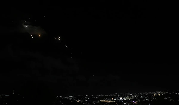 Rockets are seen over occupied al-Quds as a siren sounds a warning of incoming missiles fired from Iran, in al-Quds, occupied Palestine, Tuesday, October 1, 2024 (AP)