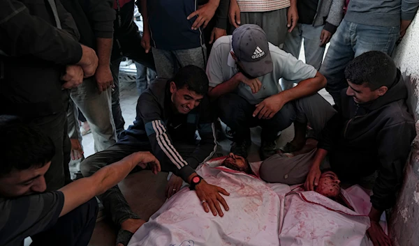 Palestinians mourn their relatives killed in the Israeli bombardment of the Gaza Strip at a hospital in Deir el-Balah, October 20, 2024. (AP)