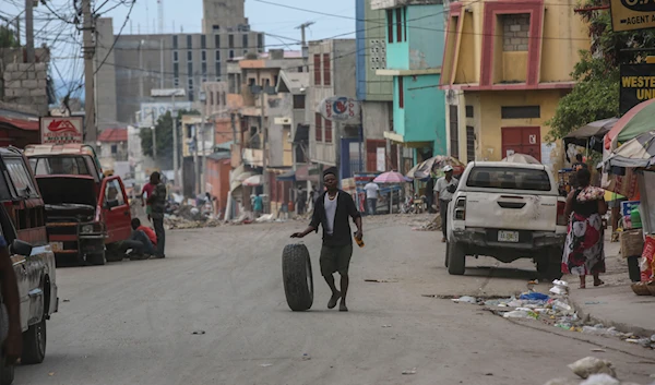 A man rolls a tire as walks along a street in Port-au-Prince, Haiti, on October 17, 2024. (AP)