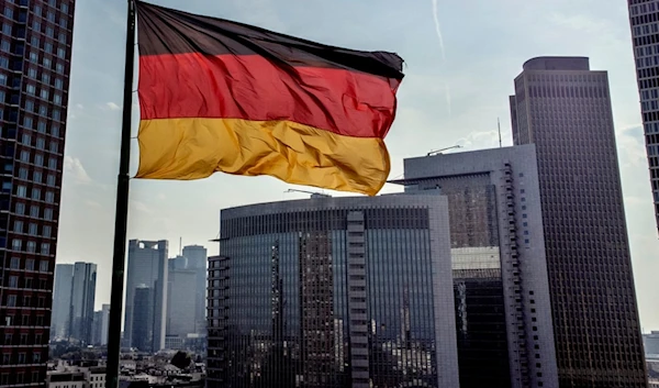 A German flag waves in front of the buildings of the banking district in Frankfurt, Germany, Friday, Aug. 30, 2024. (AP Photo/Michael Probst)