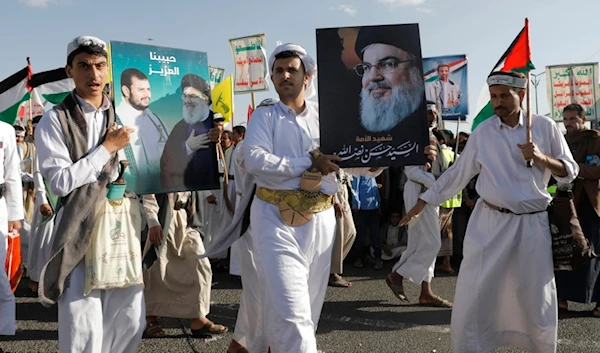 Houthi supporters raise a poster of martyred Hezbollah leader Sayyed Hassan Nasrallah during a rally to commemorate the one-year anniversary of the war on Gaza, in Sanaa, Yemen, Monday, October 7, 2024 (AP)