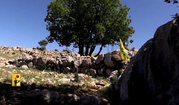 A Hezbollah fighter bears the flag of the Islamic Resistance movement in an undisclosed location, possibly in southern Lebanon (Undated/Islamic Resistance in Lebanon Military Media)