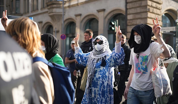 Pro-Palestinians demonstrators who show the victory sign are escorted by police as they leave a building of the Humboldt University in Berlin, Germany, on May 23, 2024. (AP)