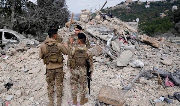 Lebanese army soldiers stand on the rubble of a destroyed building at the site of Monday's Israeli airstrike in Aito village, north Lebanon, Tuesday, Oct. 15, 2024. (AP)