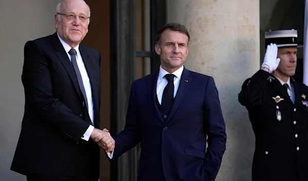 French President Emmanuel Macron welcomes Lebanese caretaker Prime Minister Najib Mikati, left, Wednesday, Oct. 23, 2024 at the Elysee Palace in Paris. (AP Photo/Louise Delmotte)