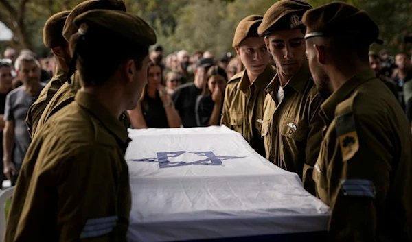 Israeli soldiers carry the flagged-covered coffin of a sergeant, killed by a Hezbollah drone attack, during his funeral near Ramot Naftali, occupied Palestine, Monday, Oct. 14, 2024. (AP)