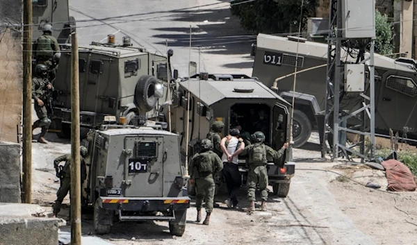 Israeli occupation forces detain a Palestinian man during a military raid against the Palestinians town of Deir al-Ghusun, near the West Bank town of Tulkarem, occupied Palestine, May 4, 2024. (AP)