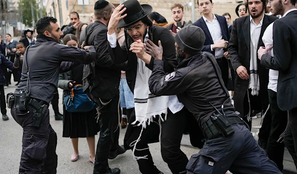 Israeli police officers disperse ultra-Orthodox Jewish men and boys blocking a road during a protest against the country's military draft in al-Quds, on February 26, 2024. (AP)