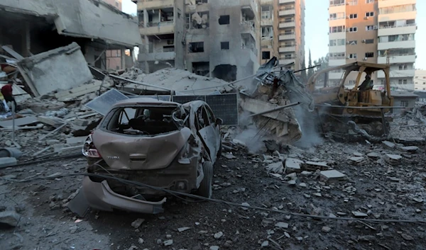 A rescue worker uses a bulldozer to remove the debris of destroyed buildings hit in Israeli occupation airstrikes in Tyre, Lebanon, Monday, Oct. 28, 2024. (AP)