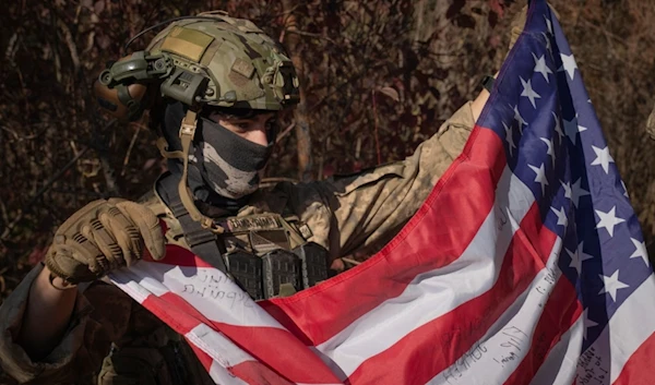 A US mercenary who serves with the 23rd separate rifle battalion of Ukraine's Armed Forces, holds the US flag near the front line in the Kharkov region, Ukraine, Saturday, Oct. 26, 2024. (AP)