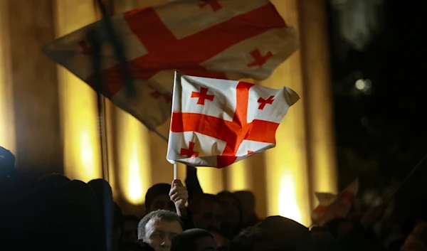 Demonstrators wave Georgian national flags during an opposition protest against the results of the parliamentary election in Tbilisi, Georgia, on Monday, Oct. 28, 2024. (AP Photo/Zurab Tsertsvadze)