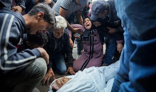 Palestinian mourn their relatives killed in the Israeli bombardment of the Gaza Strip at a hospital morque in Deir al-Balah,Tuesday,October 29,2024. (AP)