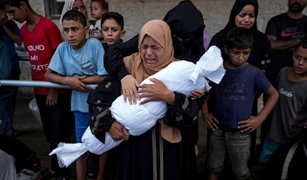 A Palestinian mother mourns her little child killed in the Israeli bombardment of the Gaza Strip, at a hospital in Deir al-Balah, on October 1, 2024. (AP)