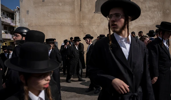 Ultra-Orthodox Jewish men attend a protest against a potential new draft law which could end their exemptions from military service in occupied al-Quds, October 31, 2024. (AP)