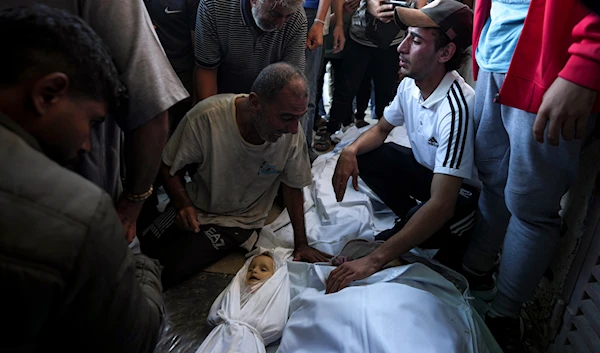 Palestinians mourn for relatives killed in the Israeli bombardment of the Gaza Strip at a hospital morgue in Deir al-Balah, on October 2, 2024. (AP)