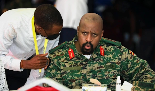 Lt. Gen. Muhoozi Kainerugaba, right, son of Uganda's President Yoweri Museveni, speaks to Attorney General Kiryowa Kiwanuka, left, at a "thanksgiving" ceremony in Entebbe, Uganda on May 7, 2022 (AP)