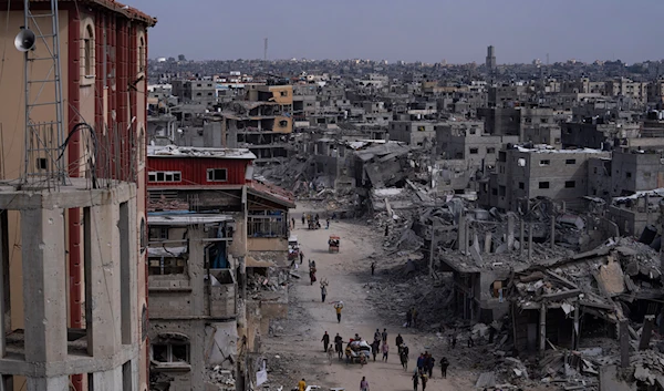 Palestinians walk through the destruction in the wake of an Israeli air and ground aggression on Khan Younis, southern Gaza Strip, on April 8, 2024. (AP)