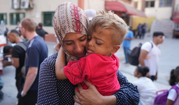 A Palestinian woman says goodbye to her sick son before leaving the Gaza Strip to get treatment abroad, southern Gaza Strip, Thursday, June 27, 2024 (AP)