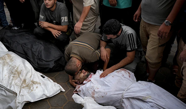 Palestinians mourn their relatives killed in the Israeli bombardment of the Gaza Strip at a hospital morgue in Deir al-Balah, on October 8, 2024. (AP)