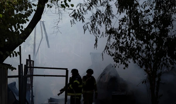 Firefighters work to extinguish a fire after a rocket, fired from Lebanon, hit a residential building in Kiryat Shmona, northern 'Israel', Oct. 9, 2024. (AP