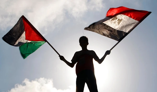 A Palestinian waves Egyptian and Palestinian flags, in Gaza City, Palestine, Aug. 6, 2012. (AP)