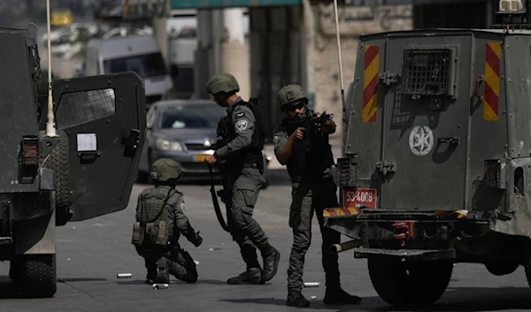 Israeli occupation forces stand near their vehicles during a military incursion into the West Bank refugee camp of Balata, occupied Palestine, Oct. 1, 2024. (AP)