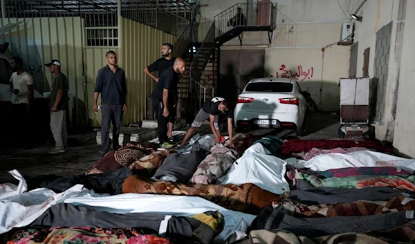 Palestinians check the bodies of their relatives killed in an Israeli bombardment of UNRWA school at Nusseirat refugee camp, in front of the morgue of al-Aqsa Martyrs hospital in Deir al-Balah, central Gaza Strip, June 6, 2024. (AP)