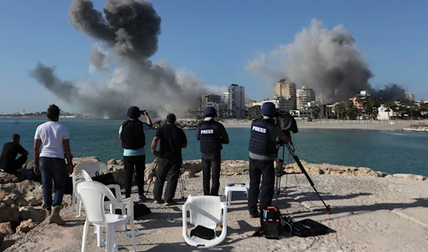 Journalists film as smoke rises from buildings hit in Israeli airstrikes in Tyre, southern Lebanon, Monday, October 28, 2024 (AP)