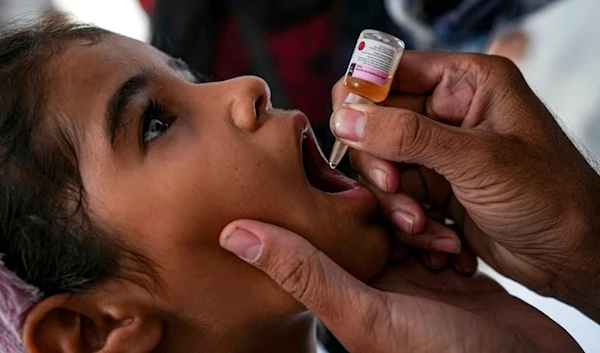 A health worker administers a polio vaccine to a child at a hospital in Deir al-Balah, central Gaza Strip, Sunday, Sept. 1, 2024. (AP Photo/Abdel Kareem Hana)