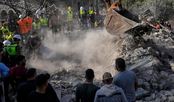 Rescue workers and people search for victims under the rubble of a destroyed house hit in an Israeli airstrike, in Almat village, northern Lebanon, Sunday, November 10, 2024 (AP)