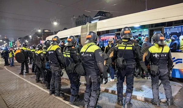 Dutch mobile Police officers stand guard after several scuffles broke out in Amsterdam following the UEFA Europa League, League phase - Matchday 4, football match between Ajax Amsterdam and Maccabi Tel Aviv, on November 8, 2024. (AFP)