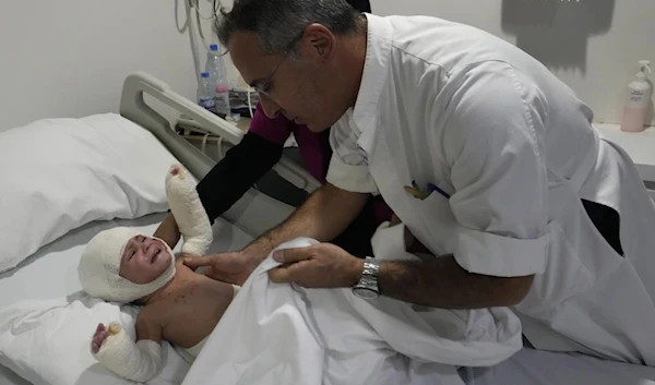 Plastic surgeon doctor Ziad Sleiman, inspects Ivana Skakye, 2, as she lies on a bed at the Geitaoui hospital where she is receiving treatment, in Beirut, Lebanon, Tuesday, Oct. 29, 2024. (AP)