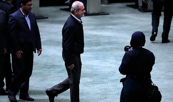 Iranian President Masoud Pezeshkian walks towards the podium to speak in an open session of parliament to debate on his next year's budget bill, in Tehran, Iran, Tuesday, October 29, 2024 (AP)