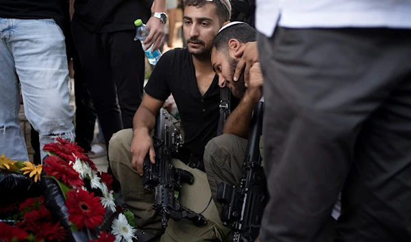 Soldiers visit the grave of Israel Defense Forces Captain Elad Siman Tov, who was killed in action in Lebanon, during his funeral in Petah Tikva, occupied Palestine, on October 18, 2024. (AP)