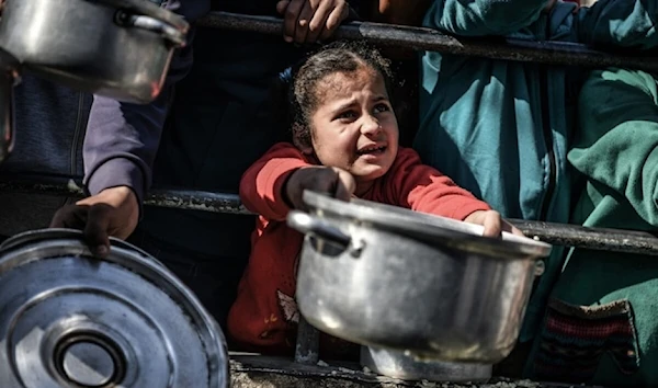 Shaima, 8-years-old, waits her turn in the crowd to get a meal from a charitable hospice that distributes free food in the city of Rafah, southern Gaza Strip (UNICEF)