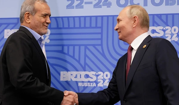 Russian President Vladimir Putin, right, and Iranian President Masoud Pezeshkian shake hands during their meeting on the sidelines of the BRICS summit in Kazan, Russia, Wednesday, Oct. 23, 2024. (AP)