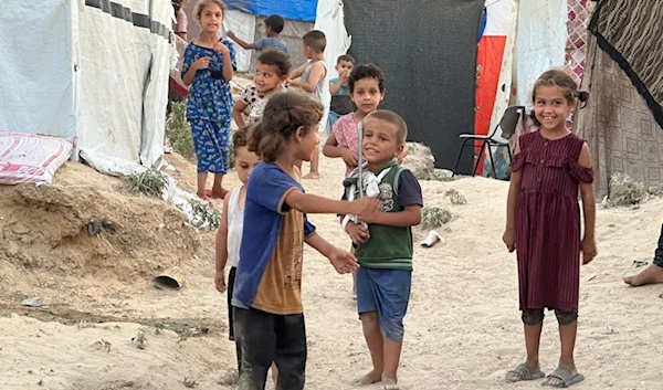 Palestinian children living in tents after being forcibly displaced from their homes amid the Israeli genocide in Gaza, August 2024 (@UNRWA / X)