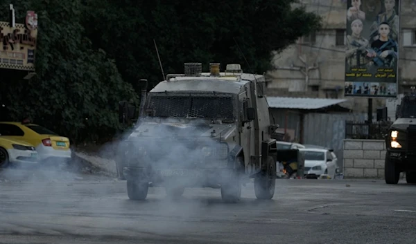 Smoke from explosives thrown by Palestinians at Israeli occupation forces' armored vehicles following a deadly raid in the Balata refugee camp in the West Bank city of Nablus, June 3, 2024. (AP)