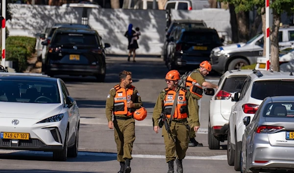 Officers from the Israeli Home Front Command military unit walk on a road near where Israel's government says a drone launched toward Israeli Prime Minister Benjamin Netanyahu's house in Caesarea, Oct. 19, 2024. (AP)