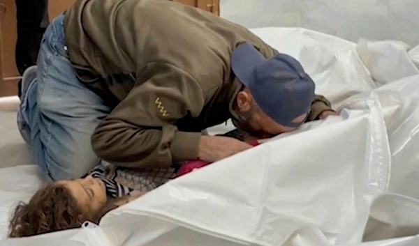 A Palestinian kisses a relative killed in Israeli airstrikes, in a morgue in the city of Khan Younis, southern Gaza Strip, Friday, Oct. 25, 2024. (AP)