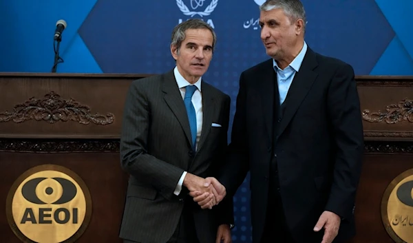 International Atomic Energy Agency Director General Rafael Mariano Grossi, left, and Iran's Atomic Energy Organization head Mohammad Eslami shake hands for media at the conclusion of their press conference in Tehran, Iran, November 14, 2024 (AP)