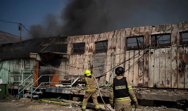 Firefighters work to extinguish a fire after a rocket, fired from Lebanon, hit a local municipality storage in Kiryat Shmona, northern Palestine, Tuesday, Sept. 24, 2024. (AP)