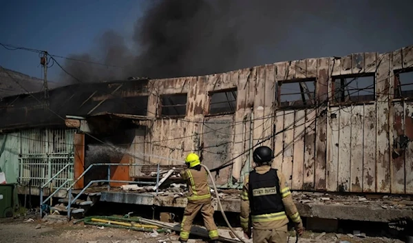 Firefighters work to extinguish a fire after a rocket, fired from Lebanon, hit a local municipality storage in Kiryat Shmona, northern Palestine, September 24, 2024. (AP)