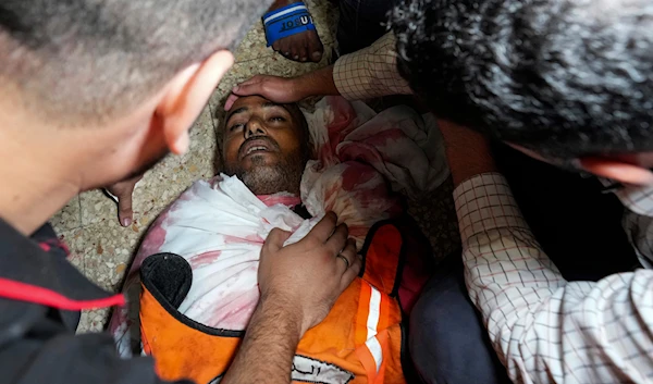 Palestinians mourn their colleague civil defense member killed in the Israeli bombardment of Nuseirat refugee camp, at the morgue of al-Aqsa Martyrs Hospital in Deir al Balah, central Gaza Strip on June 27, 2024. (AP)