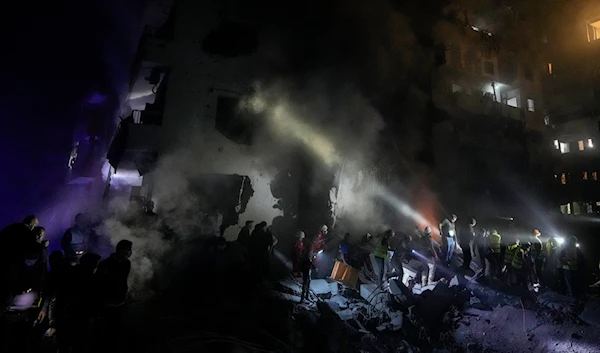 Rescue workers and people search for victims at the site of an Israeli airstrike in Beirut, Lebanon, early on November 23, 2024. (AP)